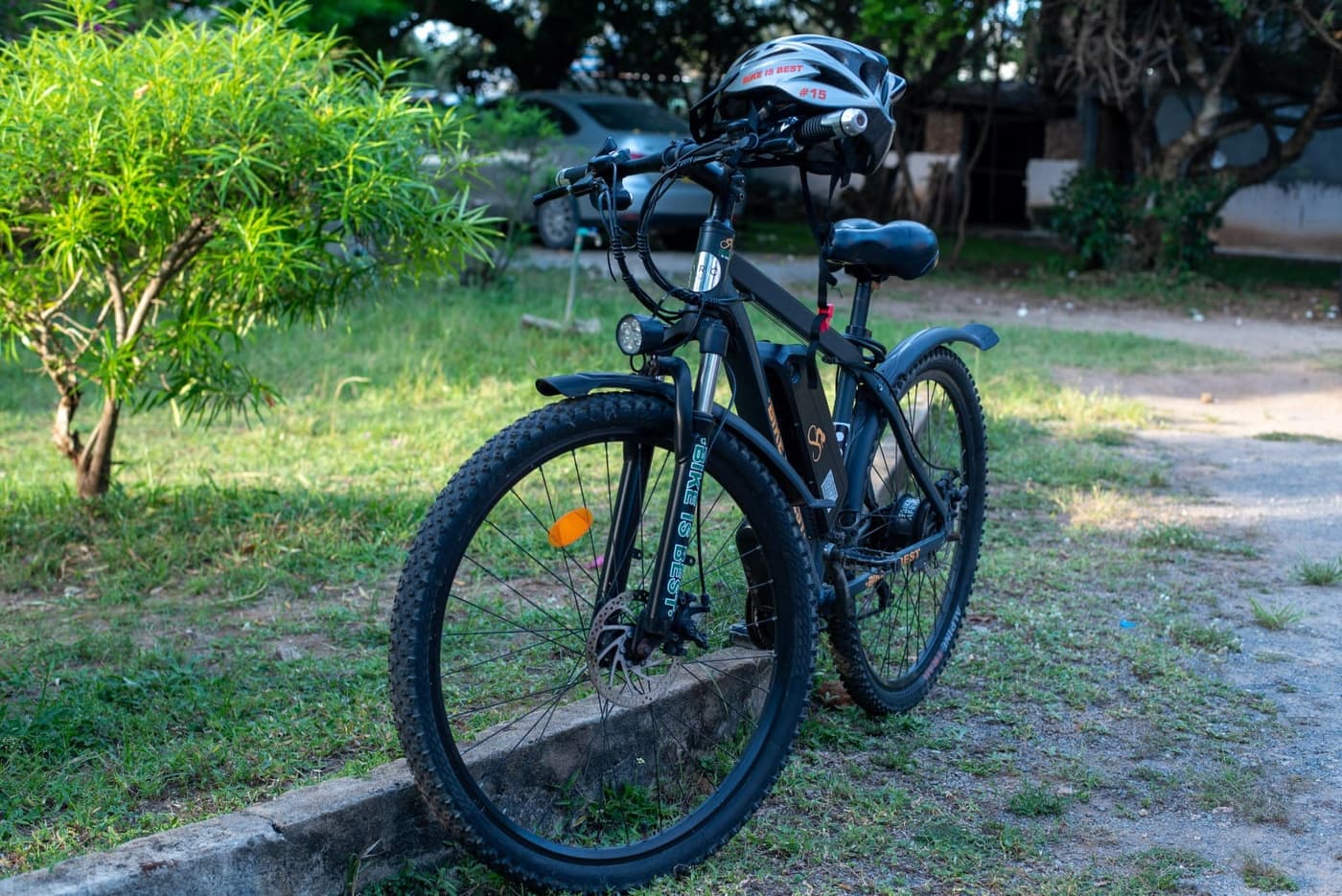 A Bike is Best electric bike with a helmet on the handlebars, parked on grass