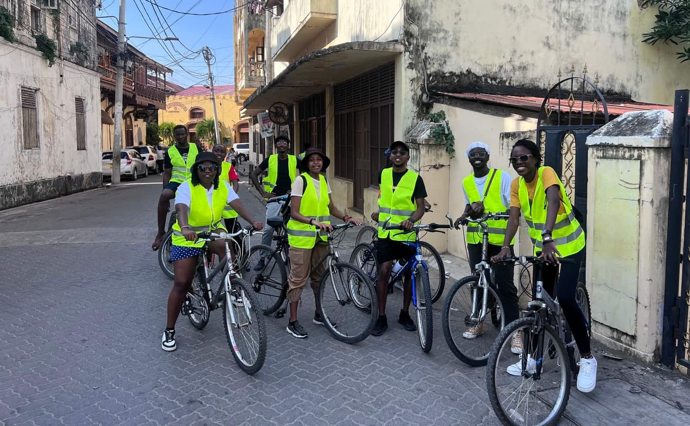 Riders in hi-vis vests pausing in a narrow Old Town street